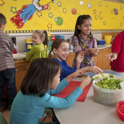 Elementary school students making a salad in the classroom. Original public domain image from Flickr